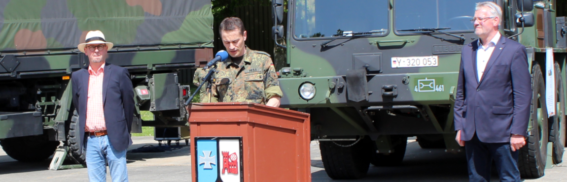 Das Bild zeigt Oberstleutnant Christoph Werle bei der Begrüßung der Gäste. Mit ihm am Rednerpult MdB Alois Gehrig (rechts) und der Bürgermeister der Stadt Walldürn Markus Günter.