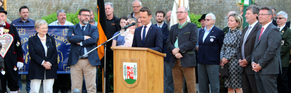 Das Bild zeigt Bürgermeister James Chéron aus Montereau am Mikrofon bei seinen sehr nachdenklichen Grußworten. Auch die anderen Gastredner nehmen mit nachdenklichen Mienen die ernsten Worte zur Kenntnis.