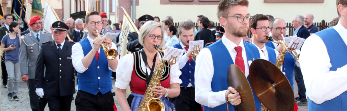 Das Bild zeigt die Fahnenabordnungen, gefolgt von allen Teinehmer an der Eröffnungszeremonie, auf dem Weg zum Schloßplatz, wo mit dem Anstich des ersten Fasses die Eröffnung ihren Höhepunkt findet.