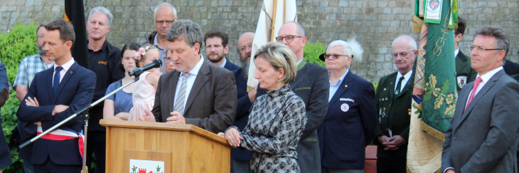 Das Bild zeigt Bürgermeister Gabor Huszar aus Szentgotthárd mit seiner Dolmetscherin bei seinem Grußworten. Bürgermeister Günter steht dabei hinter den beiden Ehrengästen. James Chèron aus Monterau (links) und Dr. Achim Brötel (am rechten Bildrand) sind aufmerksame Zuhörer.