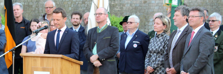 Das Bild zeigt Bürgermeister James Chéron aus Montereau am Mikrofon bei seinen sehr nachdenklichen Grußworten. Auch die anderen Gastredner nehmen mit nachdenklichen Mienen die ernsten Worte zur Kenntnis.