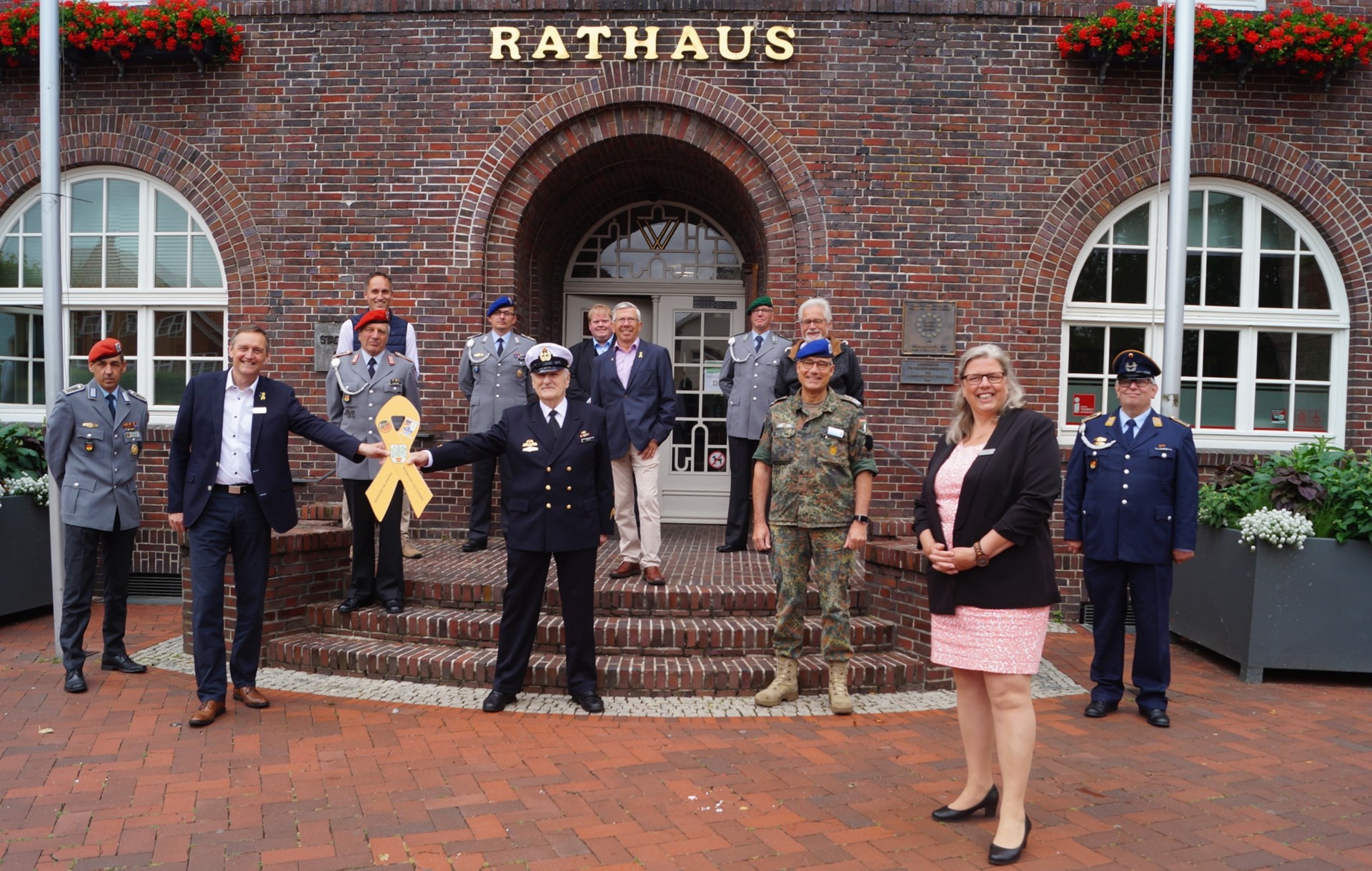 Übergabe der Gelben Schleife an den Bürgermeister der Kreisstadt Westerstede vor dem Rathaus.