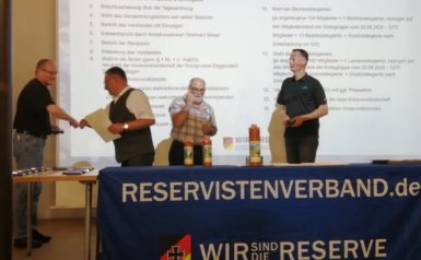 Wandinger übernimmt von KrsVors Georg Harass Medaille und Urkunde für Nacht-Orientierungsmarsch 2020. Veranstalter Andreas Hackl, Vorsitzender der RK Lalling (Bildmitte) moderiert. 